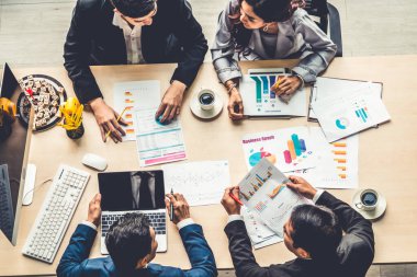 İş adamları grup toplantısı ofiste yukarıdan çekildi. İş kadınları, iş adamları ve ofis çalışanları, proje planlama belgeleriyle takım konferansında toplantı masasında çalışıyorlar. .