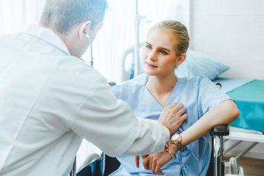 Profesyonel üniformalı doktor hastanedeki ya da klinikteki hastayı muayene ediyor. Sağlık, sağlık ve doktor hizmetleri konsepti.