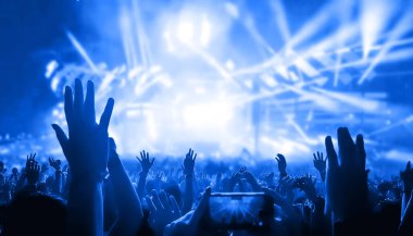 Mutlu insanlar gece kulübü DJ parti konserinde dans eder ve sahnede DJ 'den elektronik dans müziği dinlerler. Siluet dolu neşeli kalabalık 2020 yılbaşı partisini kutluyor. İnsanların yaşam tarzı DJ gece hayatı.