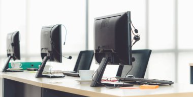 Çağrı merkezi bilgisayarları ve kulaklıklar ofiste. Telefon görüşmesinde tele pazarlama ve müşteri destek acentesi hizmetleri sunar.