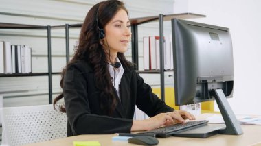 Ofiste çalışan kulaklık takan işadamları uzak müşteri ya da meslektaşlarını desteklemek için çalışıyorlar. Arama merkezi, tele pazarlama, müşteri destek acentesi telefon görüşmesinde hizmet sunar.