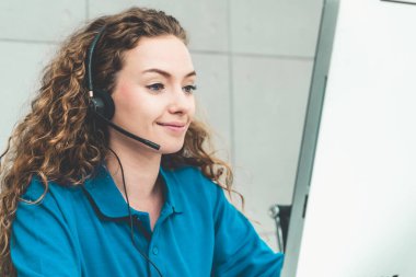 Ofiste çalışan kulaklık takan işadamları uzak müşteri ya da meslektaşlarını desteklemek için çalışıyorlar. Arama merkezi, tele pazarlama, müşteri destek acentesi telefon görüşmesinde hizmet sunar.