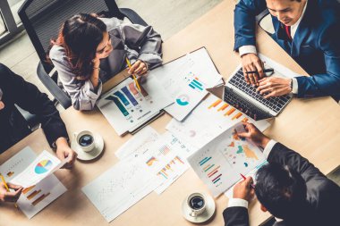 İş adamları grup toplantısı ofiste yukarıdan çekildi. İş kadınları, iş adamları ve ofis çalışanları, proje planlama belgeleriyle takım konferansında toplantı masasında çalışıyorlar. .