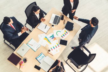İş adamları grup toplantısı ofiste yukarıdan çekildi. İş kadınları, iş adamları ve ofis çalışanları, proje planlama belgeleriyle takım konferansında toplantı masasında çalışıyorlar. .