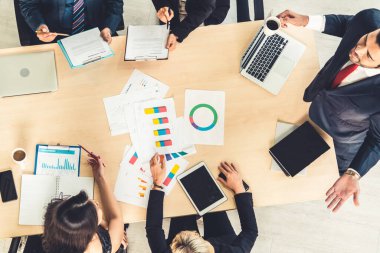İş adamları grup toplantısı ofiste yukarıdan çekildi. İş kadınları, iş adamları ve ofis çalışanları, proje planlama belgeleriyle takım konferansında toplantı masasında çalışıyorlar. .