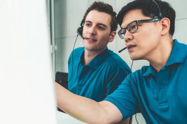 Ofiste çalışan kulaklık takan işadamları uzak müşteri ya da meslektaşlarını desteklemek için çalışıyorlar. Arama merkezi, tele pazarlama, müşteri destek acentesi telefon görüşmesinde hizmet sunar.