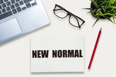 COVID 19 koronavirüsünden etkilenen yeni normal konsept, yaşam tarzımızı değiştirip, ofis masasında yazılan not defterinde anormalliğin yeni normal haline gelmesiyle ortaya çıkan yeni bir normal konsept. .