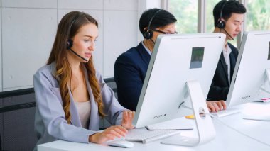 Ofiste çalışan kulaklık takan işadamları uzak müşteri ya da meslektaşlarını desteklemek için çalışıyorlar. Arama merkezi, tele pazarlama, müşteri destek acentesi telefon görüşmesinde hizmet sunar.