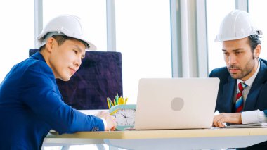 Mühendis ve mimar, mühendislik ve mimari proje planlaması hakkında ofis masasında bir araya geldiler. .