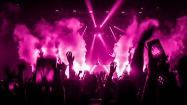 Mutlu insanlar gece kulübü DJ parti konserinde dans eder ve sahnede DJ 'den elektronik dans müziği dinlerler. Siluet dolu neşeli kalabalık 2020 yılbaşı partisini kutluyor. İnsanların yaşam tarzı DJ gece hayatı.