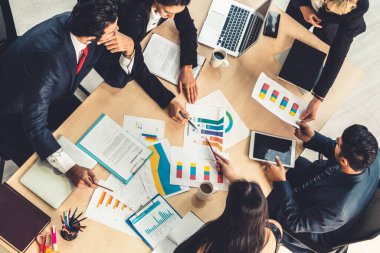 İş adamları grup toplantısı ofiste yukarıdan çekildi. İş kadınları, iş adamları ve ofis çalışanları, proje planlama belgeleriyle takım konferansında toplantı masasında çalışıyorlar. .