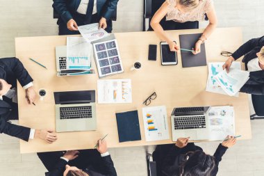 İş adamları grup toplantısı ofiste yukarıdan çekildi. İş kadınları, iş adamları ve ofis çalışanları, proje planlama belgeleriyle takım konferansında toplantı masasında çalışıyorlar. .
