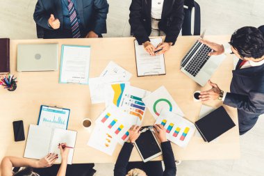İş adamları grup toplantısı ofiste yukarıdan çekildi. İş kadınları, iş adamları ve ofis çalışanları, proje planlama belgeleriyle takım konferansında toplantı masasında çalışıyorlar. .