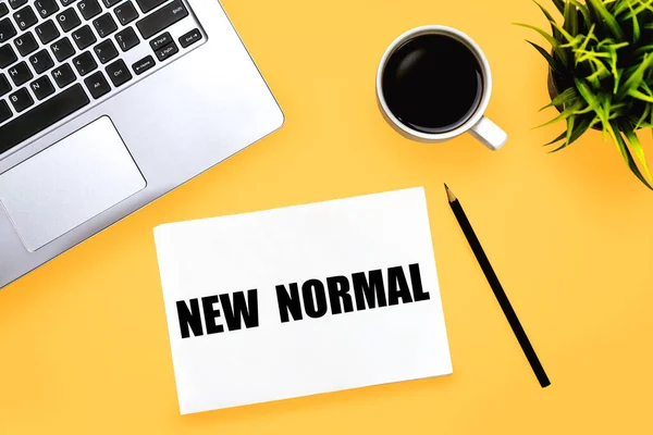 New normal concept effected by COVID 19 coronavirus that changes our lifestyle to new normal presented in word written in notebook on office desk when abnormal becomes new normal .