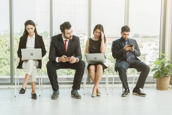 Job seekers and applicants waiting for interview on chairs in office. Job application and recruitment interview qualification concept.