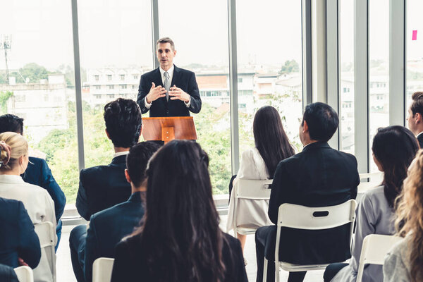 Встреча группы деловых людей на семинаре. Аудитория слушает инструктора на тренинге по обучению сотрудников. Форум сообщества офисных работников с экспертным докладчиком .