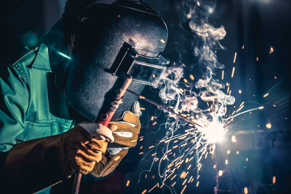 Metal welding steel works using electric arc welding machine to weld steel at factory. Metalwork manufacturing and construction maintenance service by manual skill labor concept.