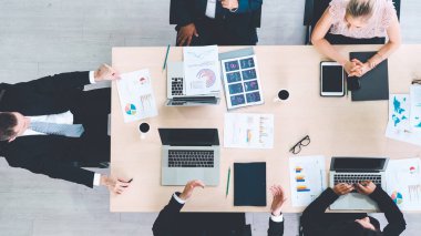 İş adamları grup toplantısı ofiste yukarıdan çekildi. İş kadınları, iş adamları ve ofis çalışanları, proje planlama belgeleriyle takım konferansında toplantı masasında çalışıyorlar. .