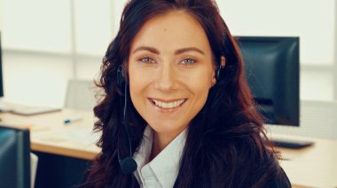 Ofiste çalışan kulaklık takan işadamları uzak müşteri ya da meslektaşlarını desteklemek için çalışıyorlar. Arama merkezi, tele pazarlama, müşteri destek acentesi telefon görüşmesinde hizmet sunar.