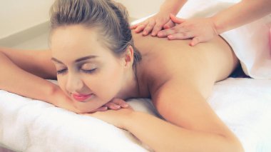 Rahat bir kadın profesyonel masaj terapistiyle lüks kaplıcalarda masaj yaptırıyor. Sağlık, şifa ve rahatlama konsepti.