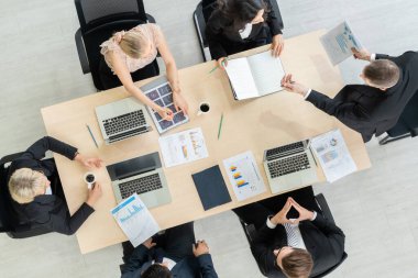 İş adamları grup toplantısı ofiste yukarıdan çekildi. İş kadınları, iş adamları ve ofis çalışanları, proje planlama belgeleriyle takım konferansında toplantı masasında çalışıyorlar. .