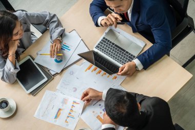 İş adamları grup toplantısı ofiste yukarıdan çekildi. İş kadınları, iş adamları ve ofis çalışanları, proje planlama belgeleriyle takım konferansında toplantı masasında çalışıyorlar. .