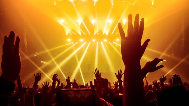 Mutlu insanlar gece kulübü DJ parti konserinde dans eder ve sahnede DJ 'den elektronik dans müziği dinlerler. Siluet dolu neşeli kalabalık 2020 yılbaşı partisini kutluyor. İnsanların yaşam tarzı DJ gece hayatı.