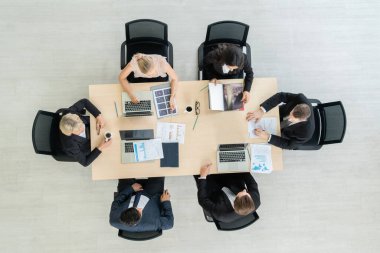 İş adamları grup toplantısı ofiste yukarıdan çekildi. İş kadınları, iş adamları ve ofis çalışanları, proje planlama belgeleriyle takım konferansında toplantı masasında çalışıyorlar. .