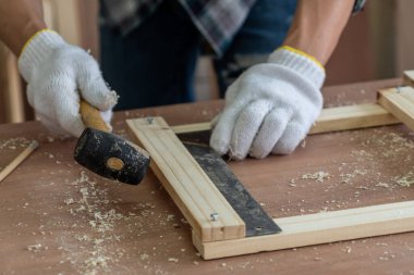 Marangoz atölyede ahşap işçiliği yapıyor. İnşaat malzemesi ya da ahşap mobilya üretiyor. Genç Asyalı marangoz zanaat için profesyonel araçlar kullanır. DIY üreticisi ve marangozluk konsepti.