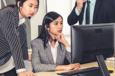 Ofiste çalışan kulaklık takan işadamları uzak müşteri ya da meslektaşlarını desteklemek için çalışıyorlar. Arama merkezi, tele pazarlama, müşteri destek acentesi telefon görüşmesinde hizmet sunar.