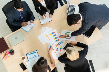 İş adamları grup toplantısı ofiste yukarıdan çekildi. İş kadınları, iş adamları ve ofis çalışanları, proje planlama belgeleriyle takım konferansında toplantı masasında çalışıyorlar. .