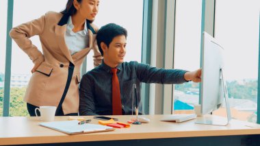 İki iş adamı toplantı odasında proje stratejisi hakkında konuşuyor. İş adamı, mali veri raporu hakkında sohbet ve tavsiyelerde bulunurken, modern işyerindeki iş arkadaşıyla proje planlamasını tartıştı.