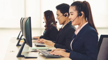 Ofiste çalışan kulaklık takan işadamları uzak müşteri ya da meslektaşlarını desteklemek için çalışıyorlar. Arama merkezi, tele pazarlama, müşteri destek acentesi telefon görüşmesinde hizmet sunar.