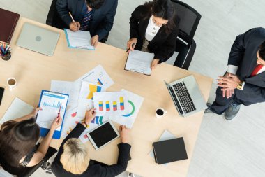 İş adamları grup toplantısı ofiste yukarıdan çekildi. İş kadınları, iş adamları ve ofis çalışanları, proje planlama belgeleriyle takım konferansında toplantı masasında çalışıyorlar. .