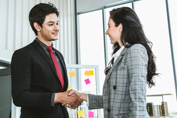 Business people handshake in corporate office showing professional agreement on a financial deal contract.