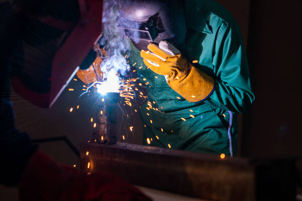 Metal welding steel works using electric arc welding machine to weld steel at factory. Metalwork manufacturing and construction maintenance service by manual skill labor concept.