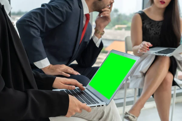 Business people in the conference room with green screen chroma key TV or computer on the office table. Diverse group of businessman and businesswoman in meeting on video conference call .