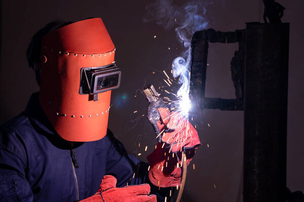 Metal welding steel works using electric arc welding machine to weld steel at factory. Metalwork manufacturing and construction maintenance service by manual skill labor concept.