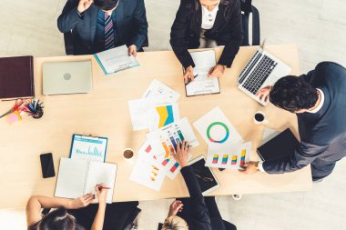 İş adamları grup toplantısı ofiste yukarıdan çekildi. İş kadınları, iş adamları ve ofis çalışanları, proje planlama belgeleriyle takım konferansında toplantı masasında çalışıyorlar. .