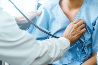 Profesyonel üniformalı doktor hastanedeki ya da klinikteki hastayı muayene ediyor. Sağlık, sağlık ve doktor hizmetleri konsepti.