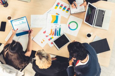 İş adamları grup toplantısı ofiste yukarıdan çekildi. İş kadınları, iş adamları ve ofis çalışanları, proje planlama belgeleriyle takım konferansında toplantı masasında çalışıyorlar. .