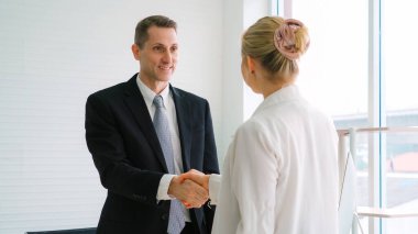 Şirket ofisinde iş adamlarının el sıkışması mali anlaşma konusunda profesyonel bir anlaşma gösteriyor.