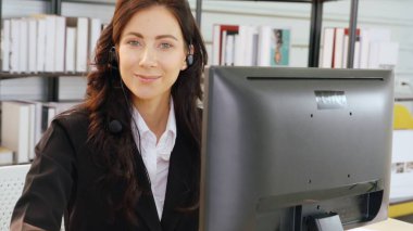 Ofiste çalışan kulaklık takan işadamları uzak müşteri ya da meslektaşlarını desteklemek için çalışıyorlar. Arama merkezi, tele pazarlama, müşteri destek acentesi telefon görüşmesinde hizmet sunar.