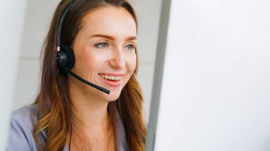 Ofiste çalışan kulaklık takan işadamları uzak müşteri ya da meslektaşlarını desteklemek için çalışıyorlar. Arama merkezi, tele pazarlama, müşteri destek acentesi telefon görüşmesinde hizmet sunar.