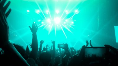 Mutlu insanlar gece kulübü DJ parti konserinde dans eder ve sahnede DJ 'den elektronik dans müziği dinlerler. Siluet dolu neşeli kalabalık 2020 yılbaşı partisini kutluyor. İnsanların yaşam tarzı DJ gece hayatı.