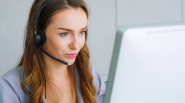 Ofiste çalışan kulaklık takan işadamları uzak müşteri ya da meslektaşlarını desteklemek için çalışıyorlar. Arama merkezi, tele pazarlama, müşteri destek acentesi telefon görüşmesinde hizmet sunar.