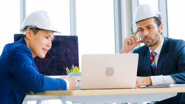 Mühendis ve mimar, mühendislik ve mimari proje planlaması hakkında ofis masasında bir araya geldiler. .