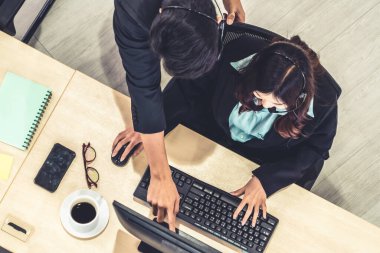 Ofiste üst kademeden kulaklık takan işadamları uzak müşteri ya da meslektaşlarını desteklemek için bilgisayarla çalışıyorlar. Çağrı merkezi, tele pazarlama acente servisi telefon ya da video konferans çağrısı.