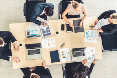 İş adamları grup toplantısı ofiste yukarıdan çekildi. İş kadınları, iş adamları ve ofis çalışanları, proje planlama belgeleriyle takım konferansında toplantı masasında çalışıyorlar. .