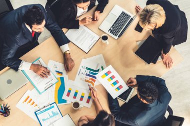 İş adamları grup toplantısı ofiste yukarıdan çekildi. İş kadınları, iş adamları ve ofis çalışanları, proje planlama belgeleriyle takım konferansında toplantı masasında çalışıyorlar. .